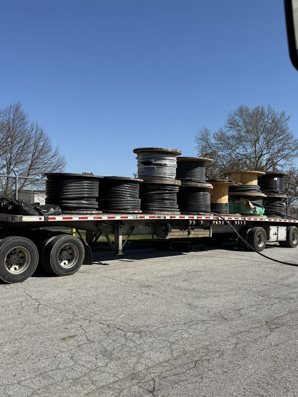 Flatbed truck loaded with surplus wire spools — we arrange and pay all freight