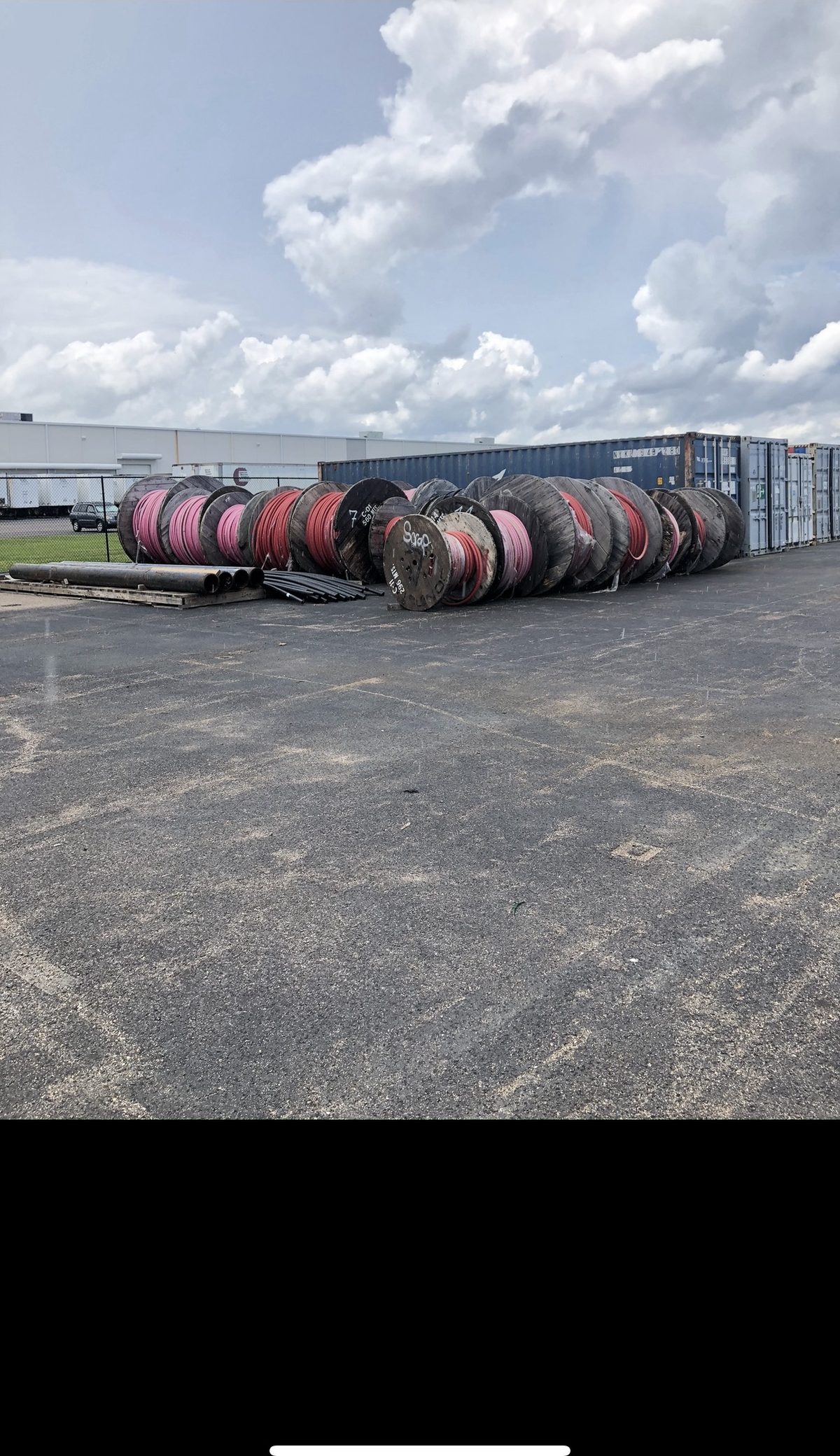 Reels of surplus electrical wire in a storage yard before pickup